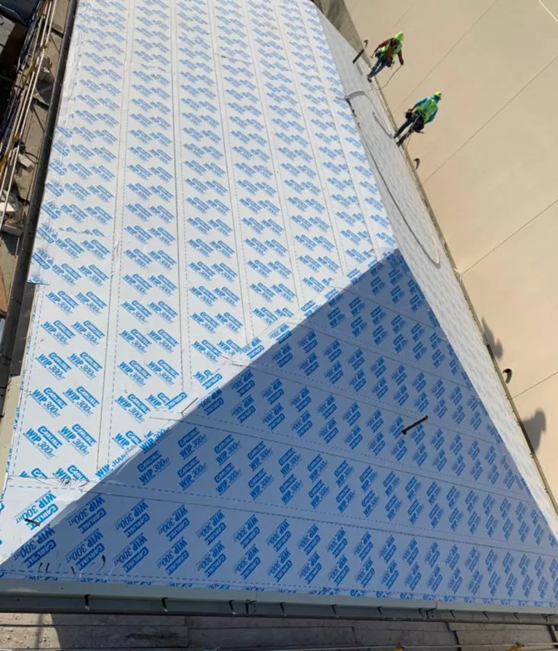 Professional roofers installing underlayment on a metal roof in Gulf Park Estates